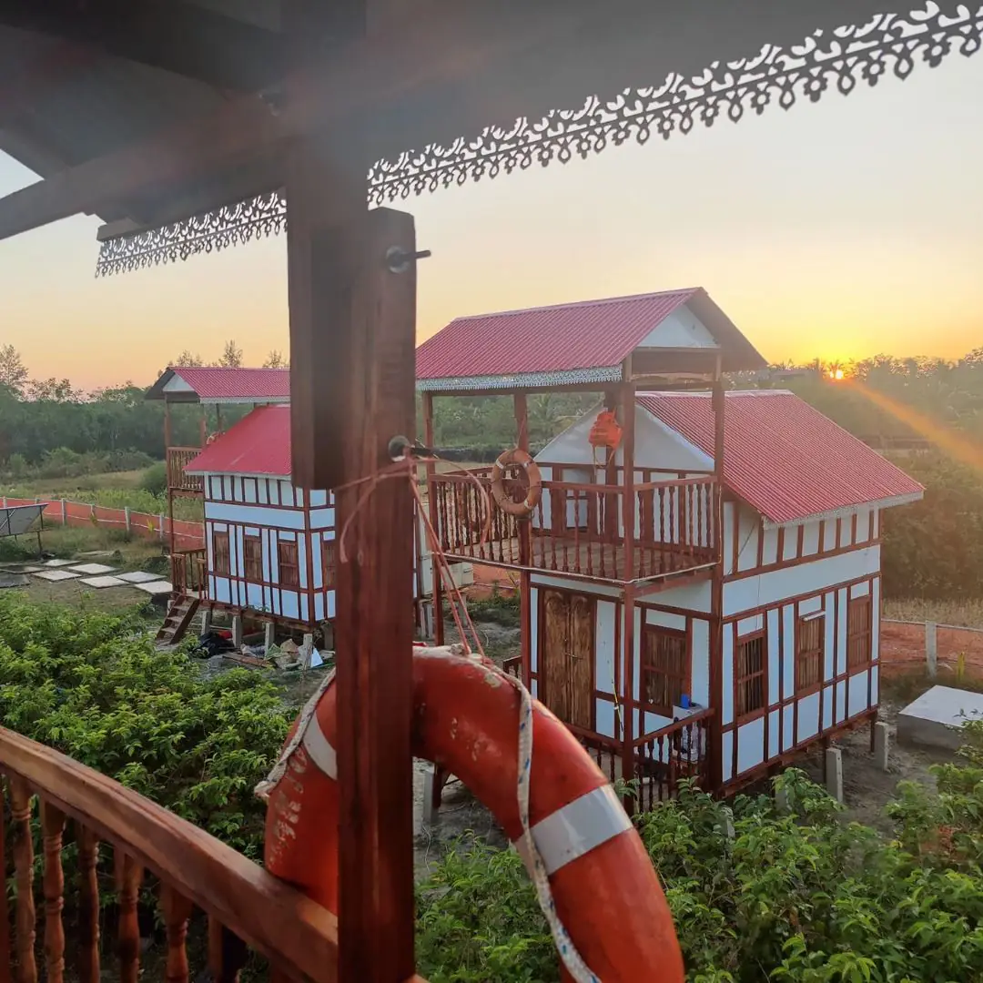 Sunset over the cottages, seen from a balcony with a life ring