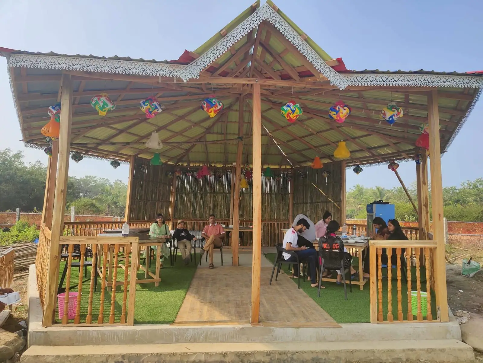 Guests at the tables of our open-air restaurant by day, under paper lanterns