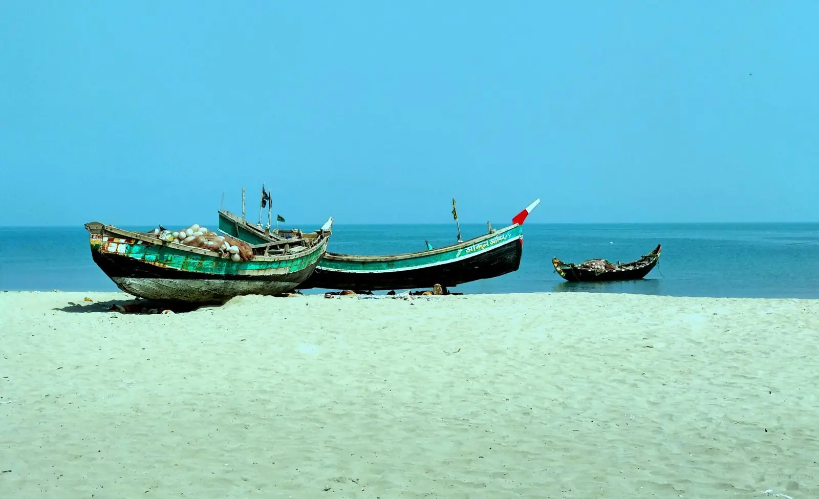 সেন্টমার্টিনে বালুর ওপর তুলে রাখা কাঠের মাছ ধরার নৌকা